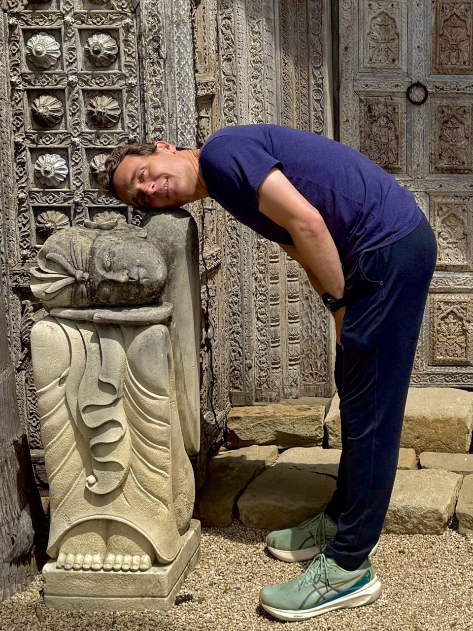 Daniel Branco, resting head to head with a stone Buddha